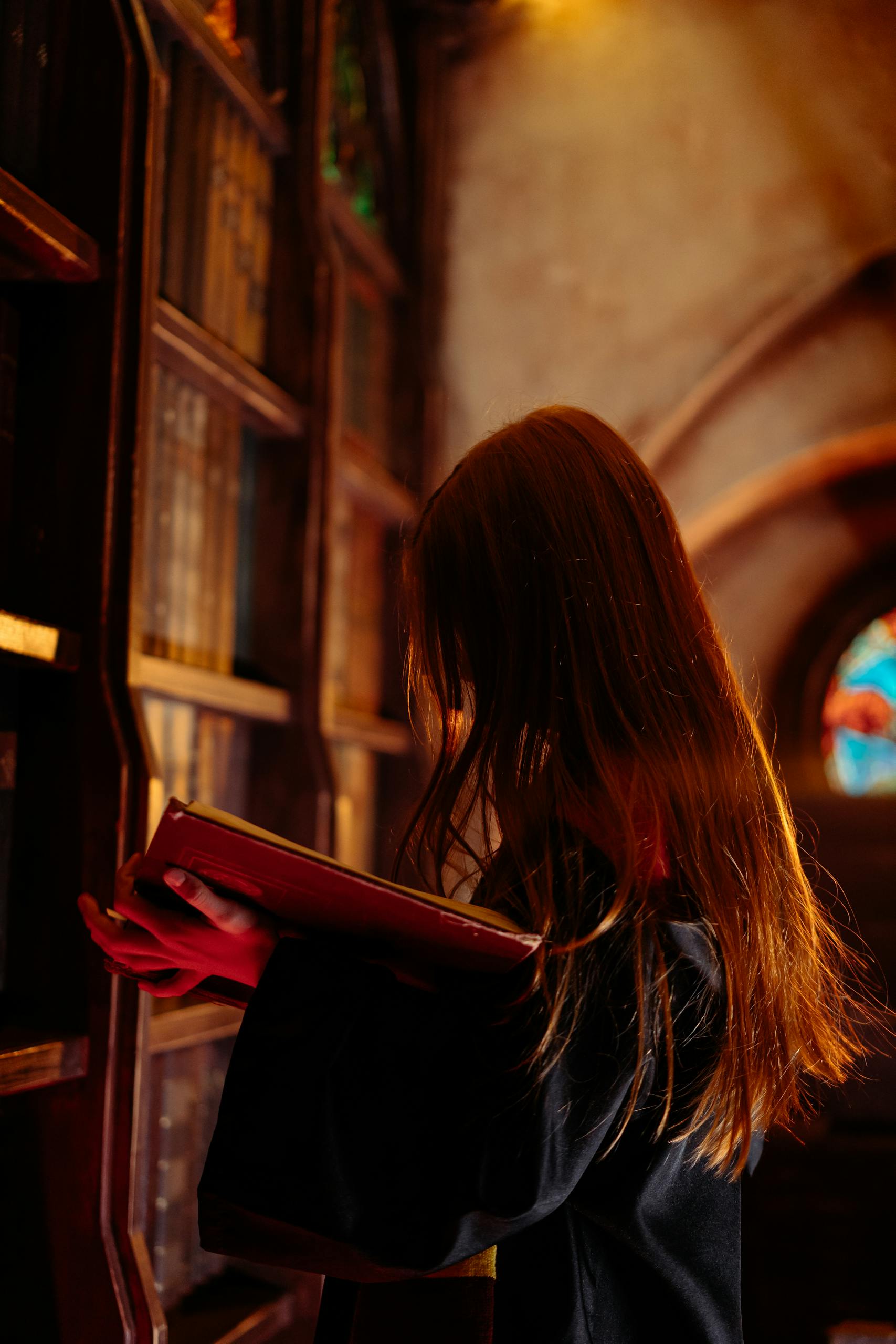 A woman reading a book in a magical, dimly lit library setting, evoking themes of fantasy and mystery.